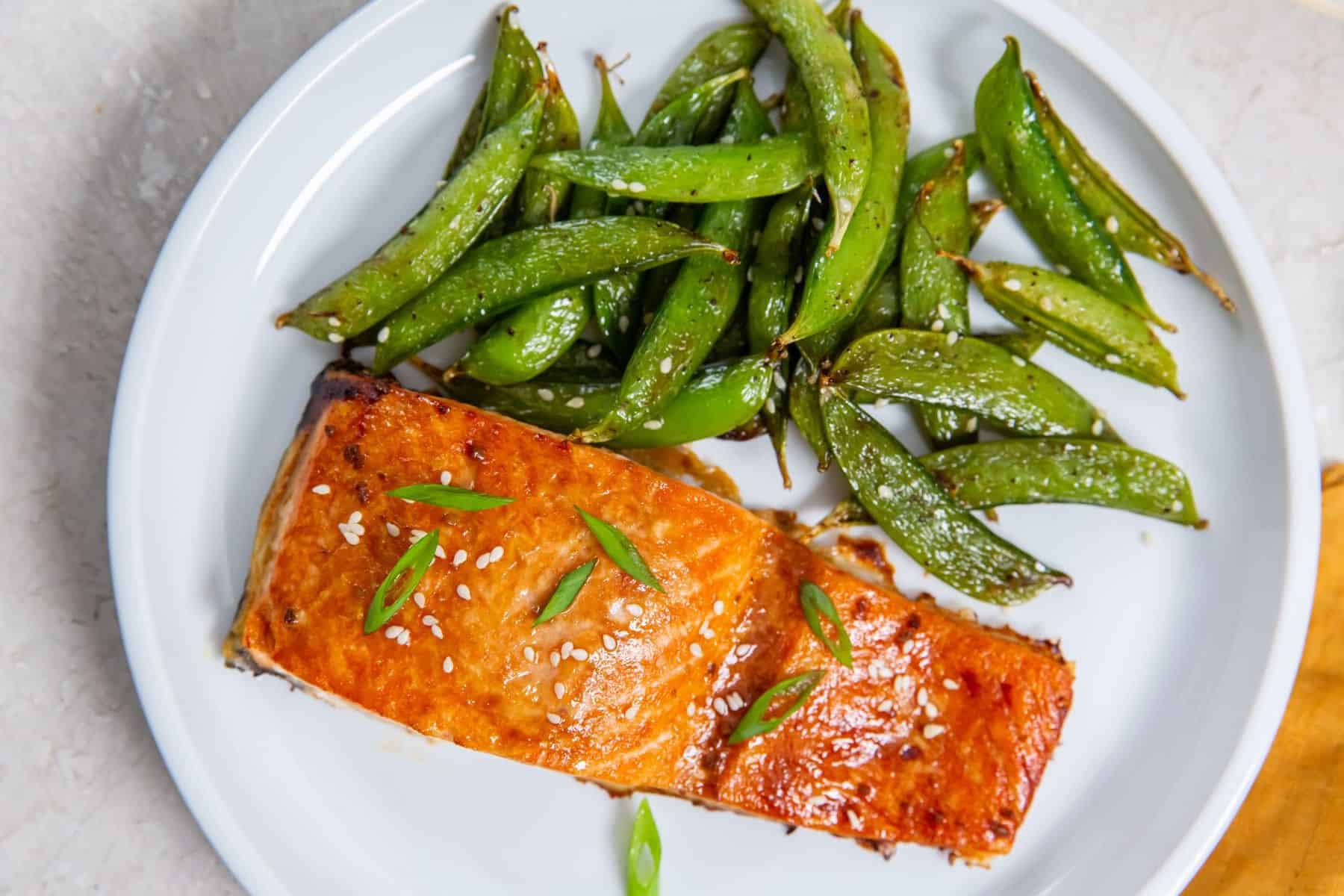 Teriyaki and snapped peas on a plate.