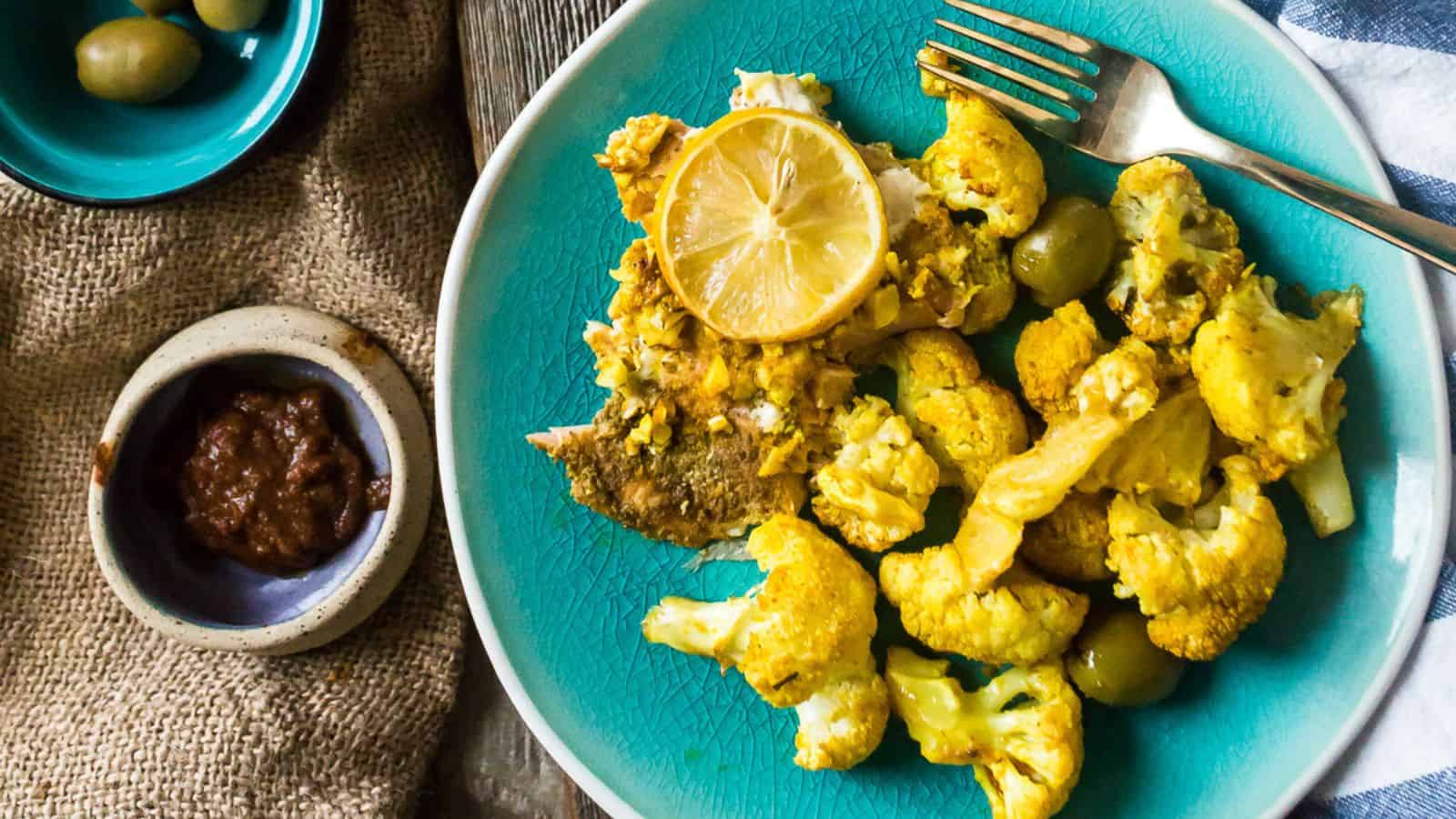 Salmon, cauliflower, and olives on a plate.
