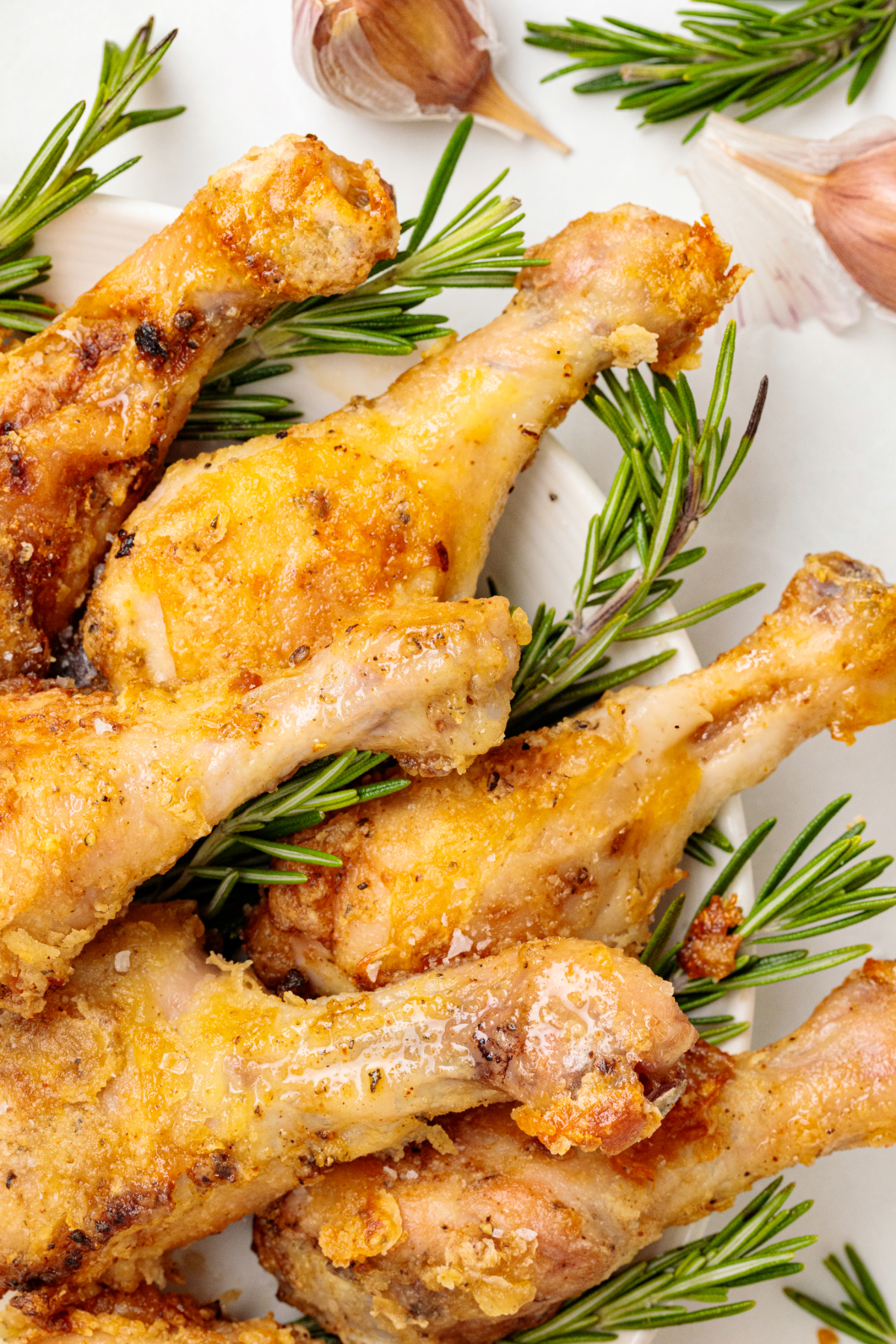 Close view of baked chicken drumsticks on a serving platter.