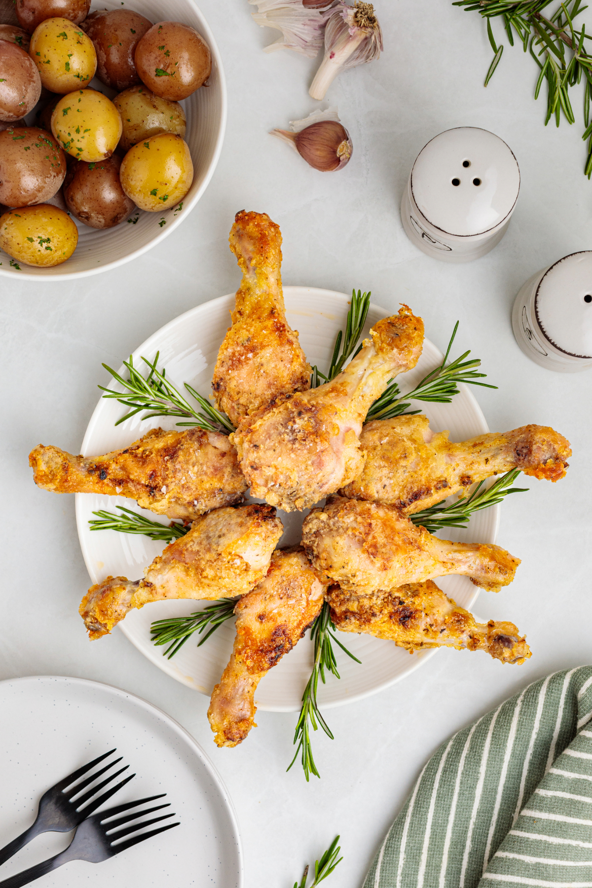Overhead view of chicken drumsticks with potatoes on the side.