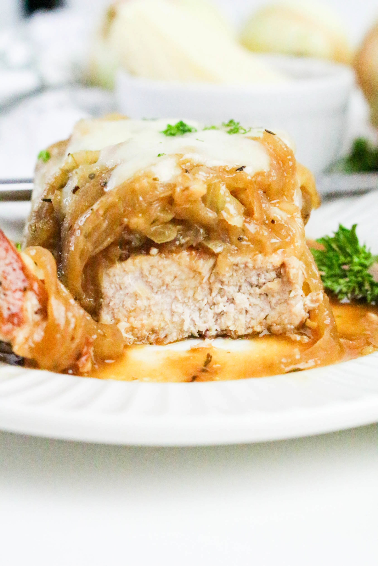 Pork chop cut open on a white dinner plate ready to eat.