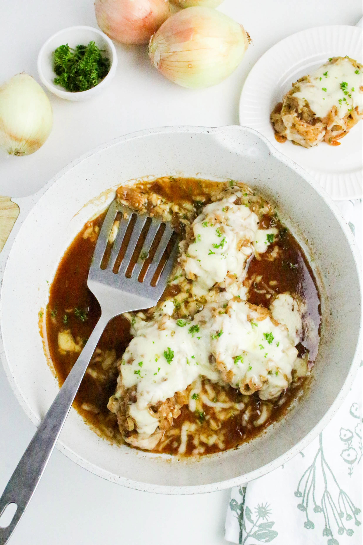 Top view of French onion pork chops with cheese on top.