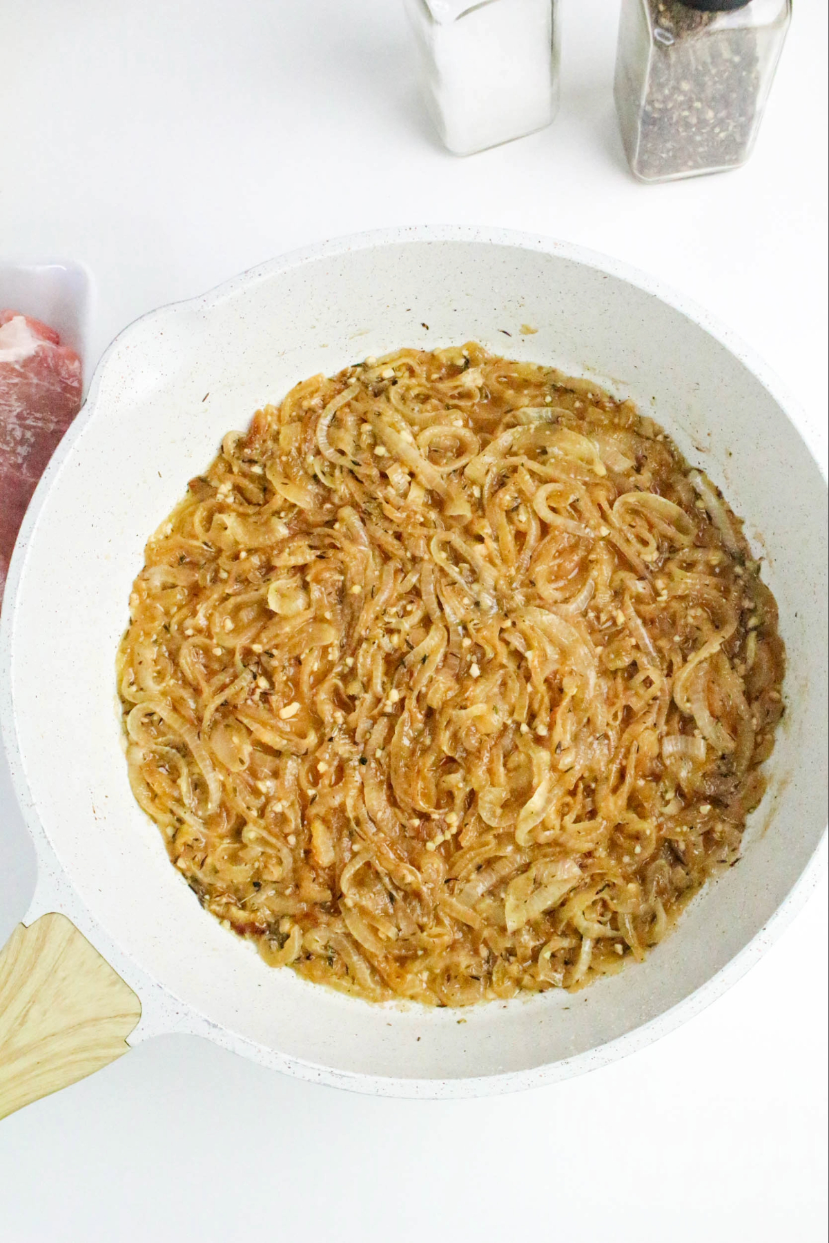 Simmering onions and broth in a skillet for French onion pork chops recipe.