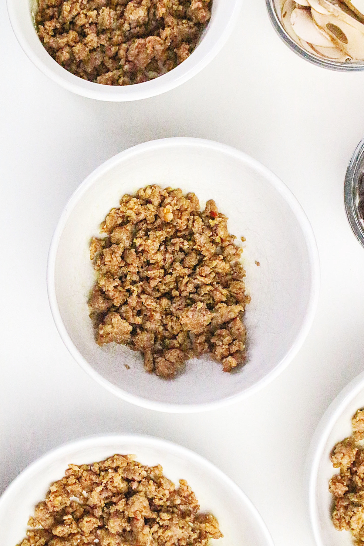 Cooked sausage drained and divided into serving bowls.