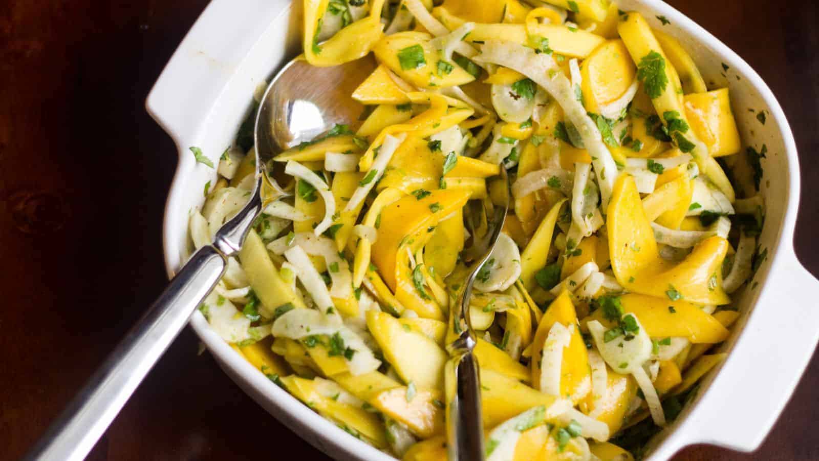 Ceramic baking dish full of mango and fennel slaw.