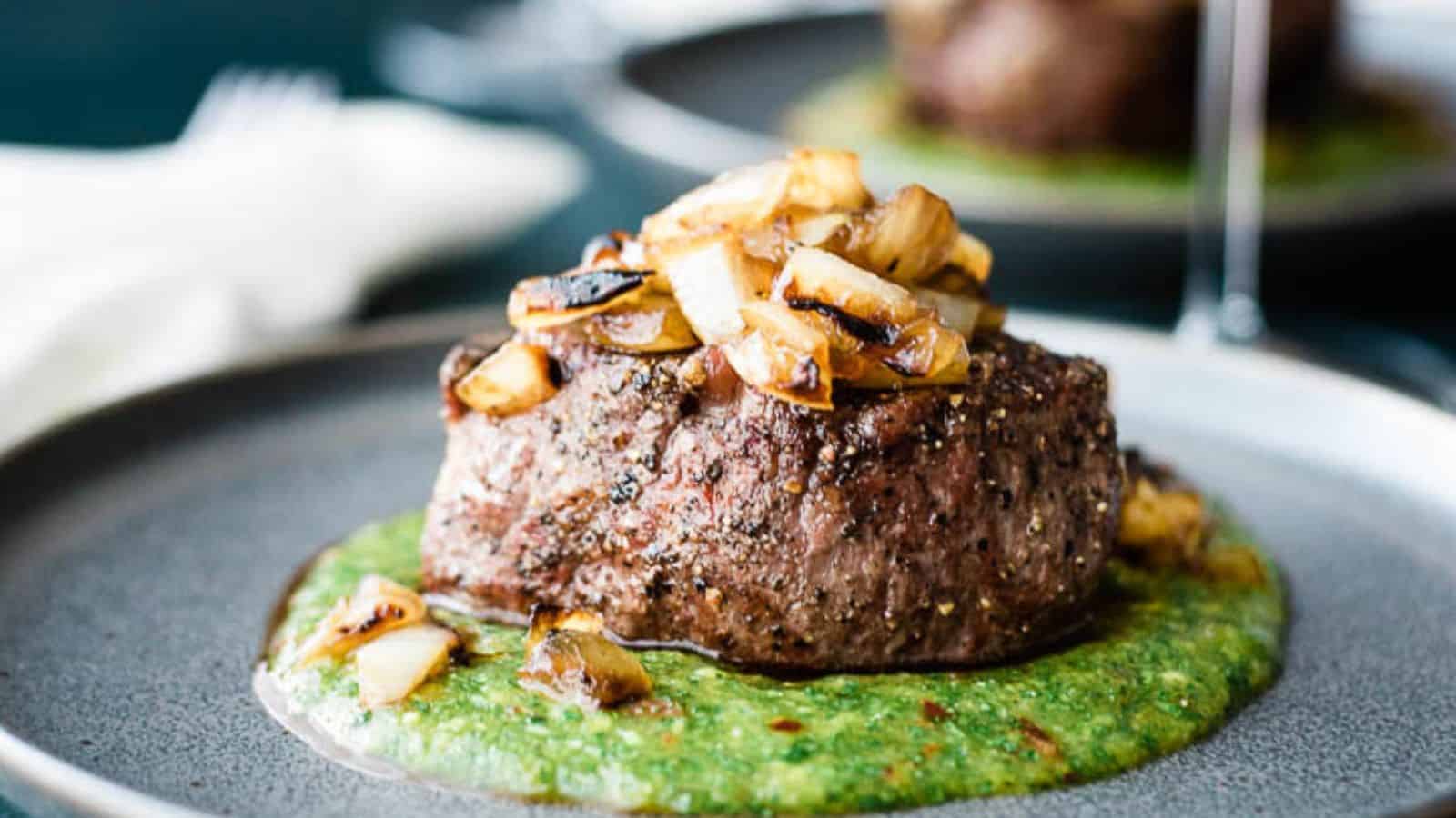 Steak on a plate topped with peach mango cilantro sauce.