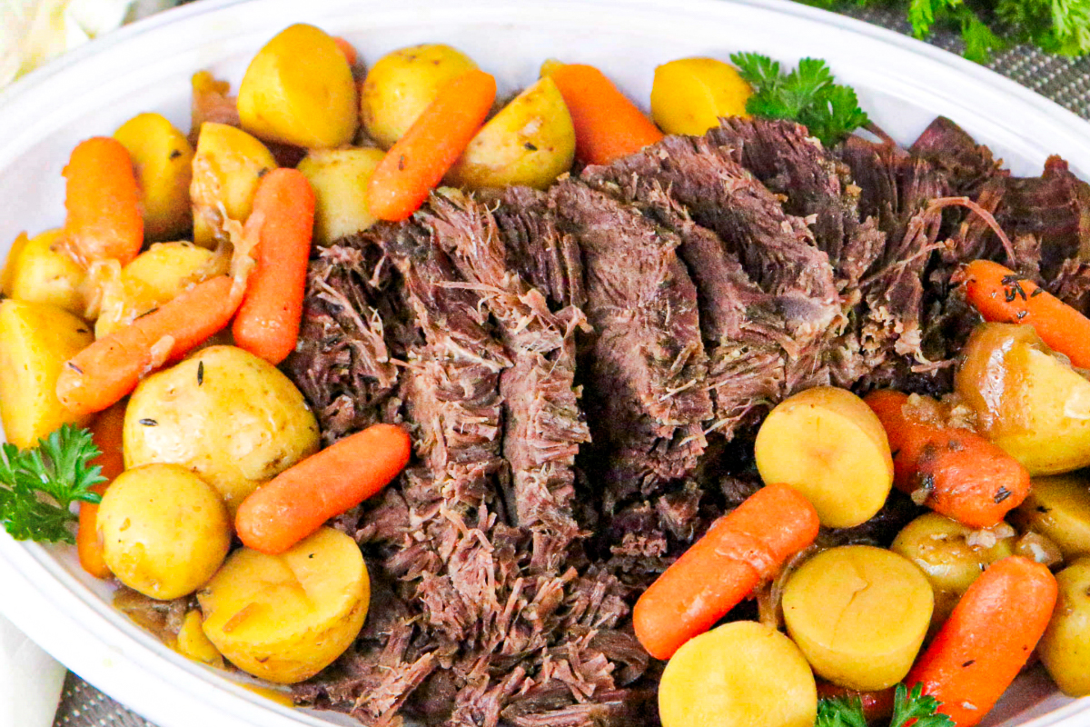 Frozen roast beef cooked in an instant pot on a white serving plate.