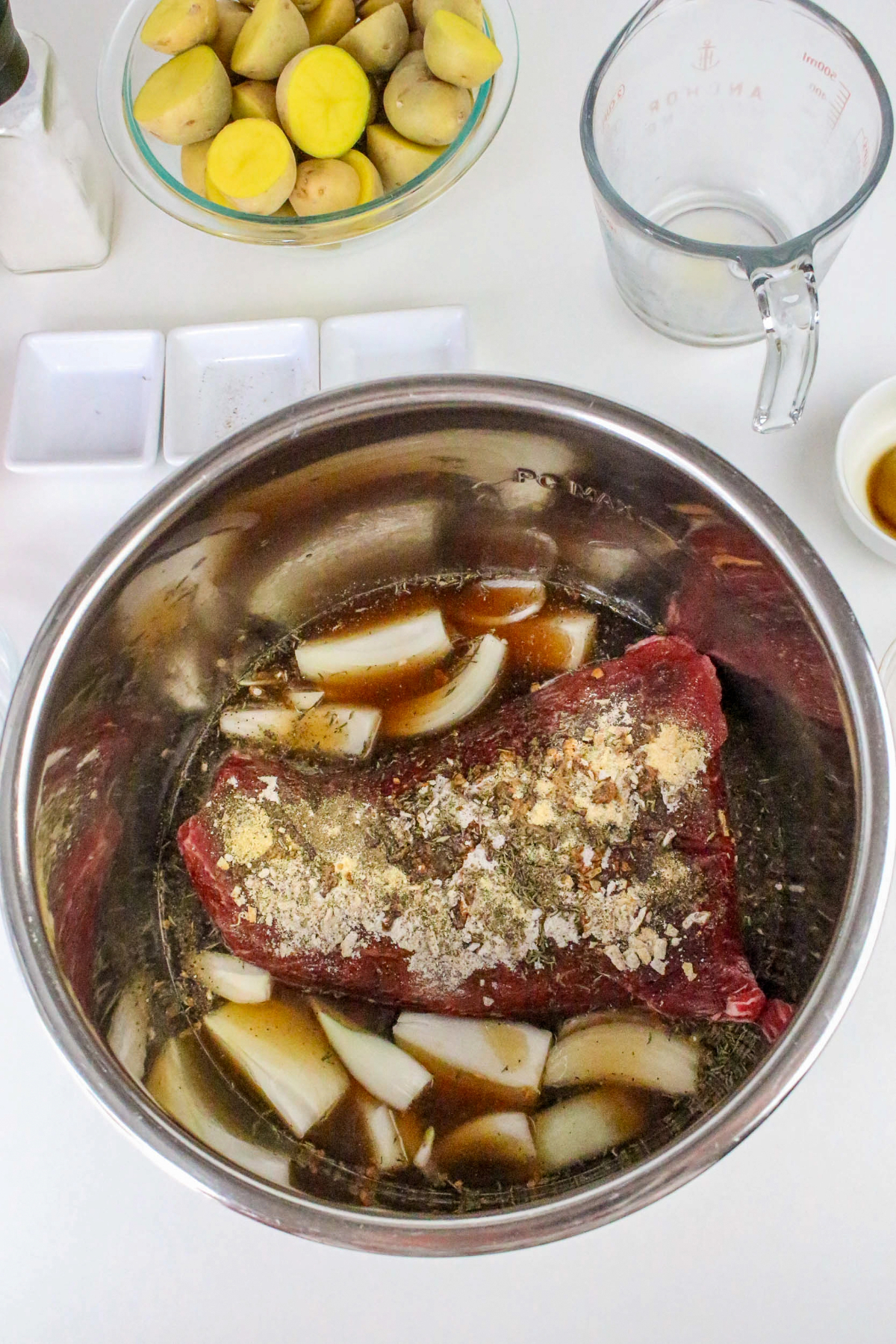 Instant pot insert with beef and onions before cooking.