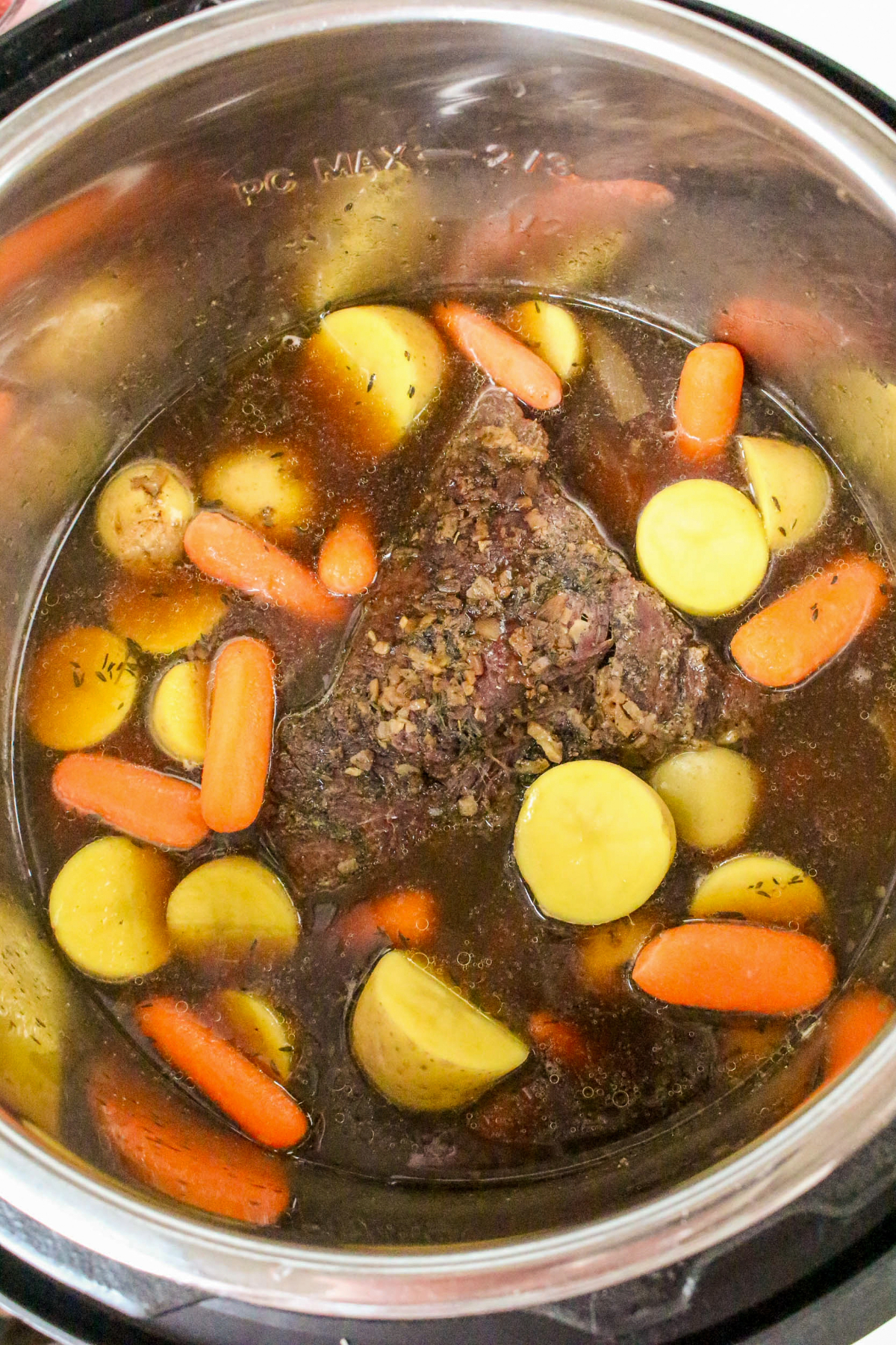 Frozen beef with vegetables in the insert of an instant pot.