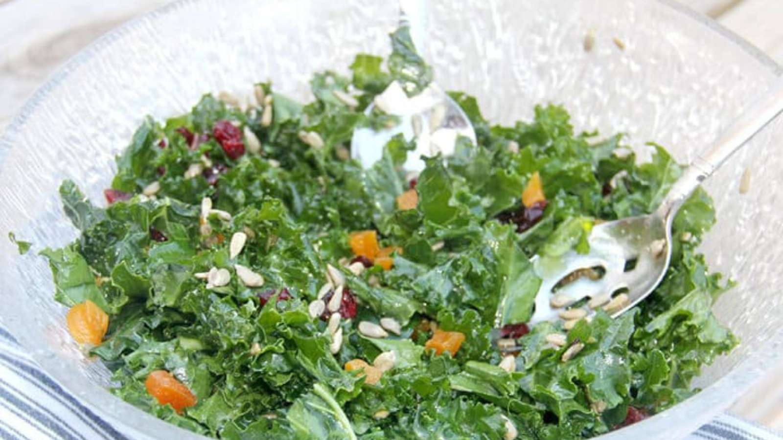 Glass bowl full of kale and mango salad.