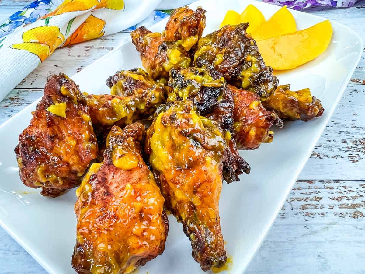 Mango chipotle wings on a white serving platter.