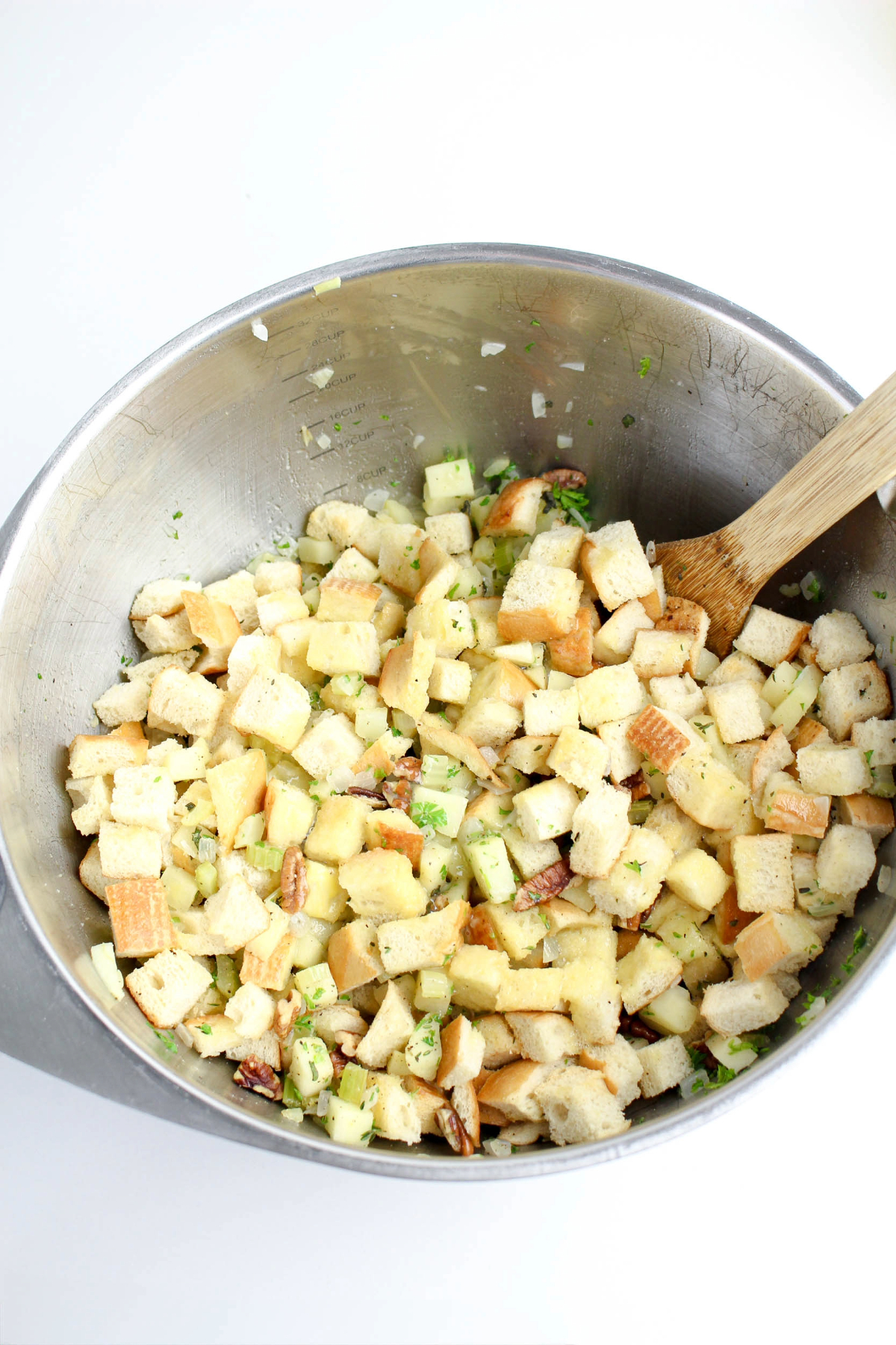Cubed bread mixed with spices in a mixing bowl.