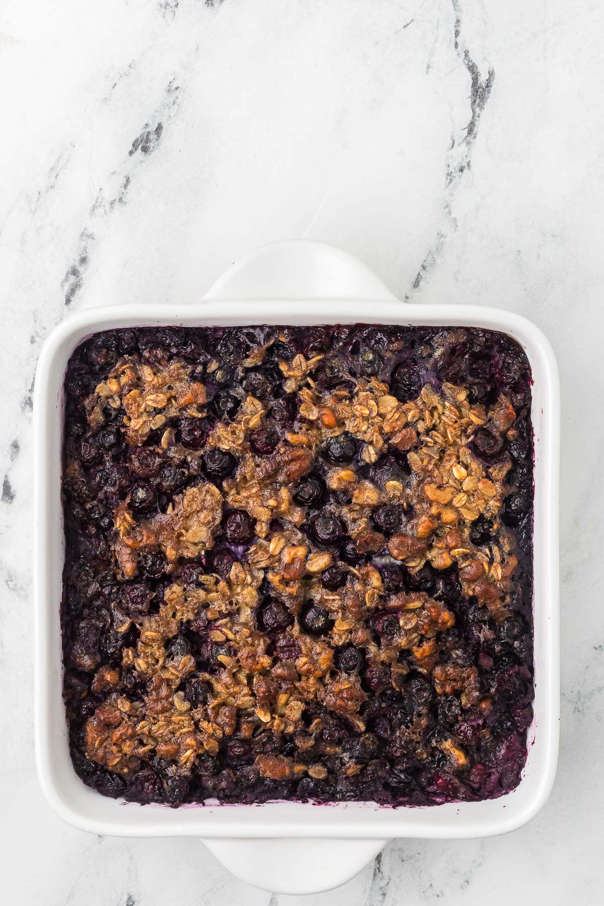 Blueberry baked oatmeal in a white baking dish ready to serve.