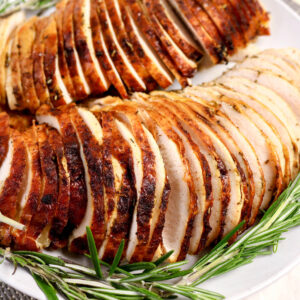 Roasted turkey breast sliced on a serving dish.