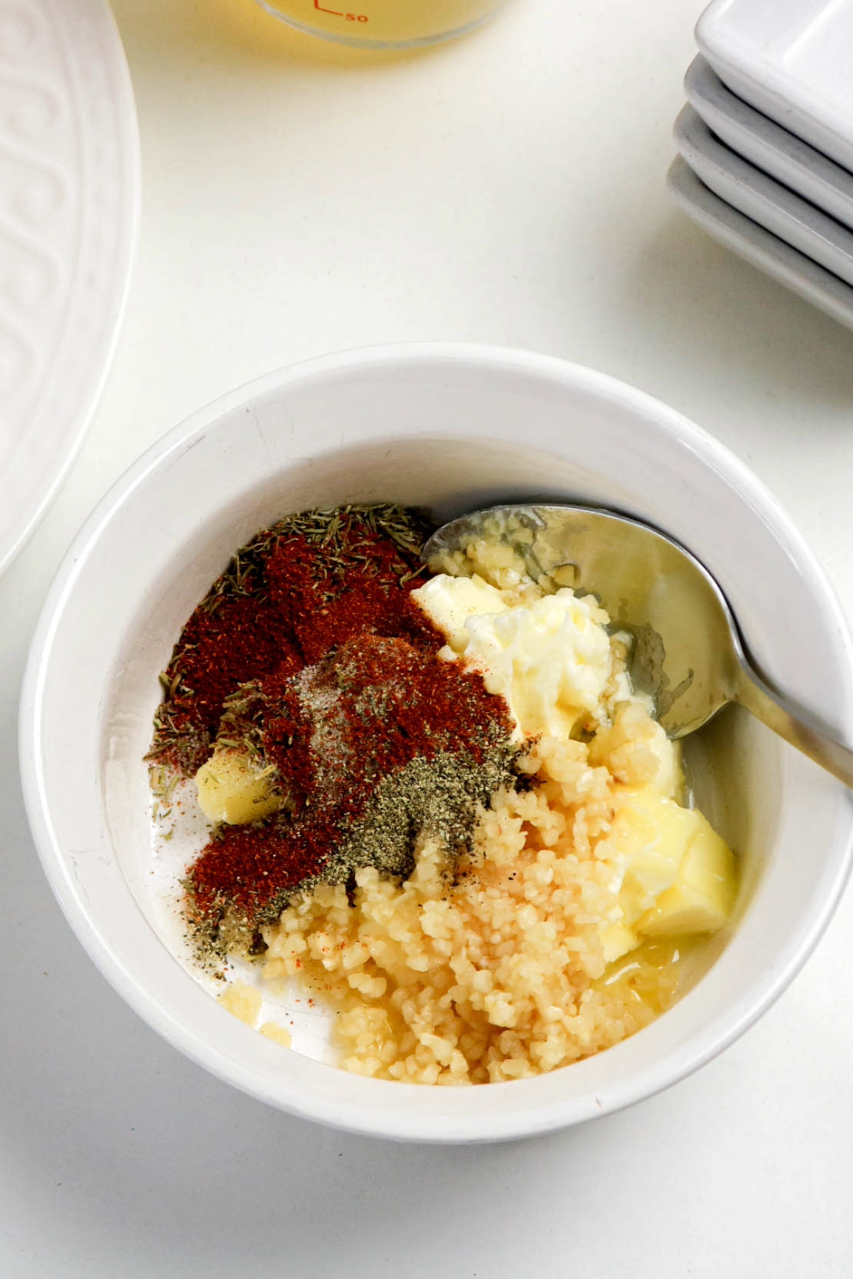 Seasoning mixture of herbs and butter in a mixing bowl before combining.