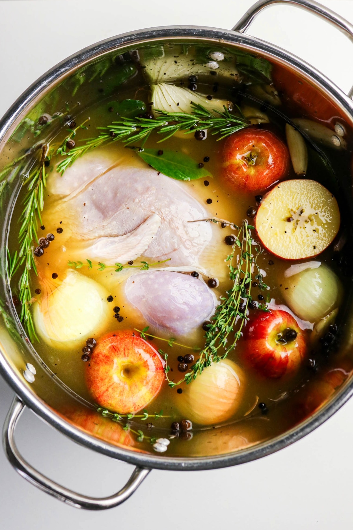 top view of turkey in a stock pot with apple cider brine mixture.
