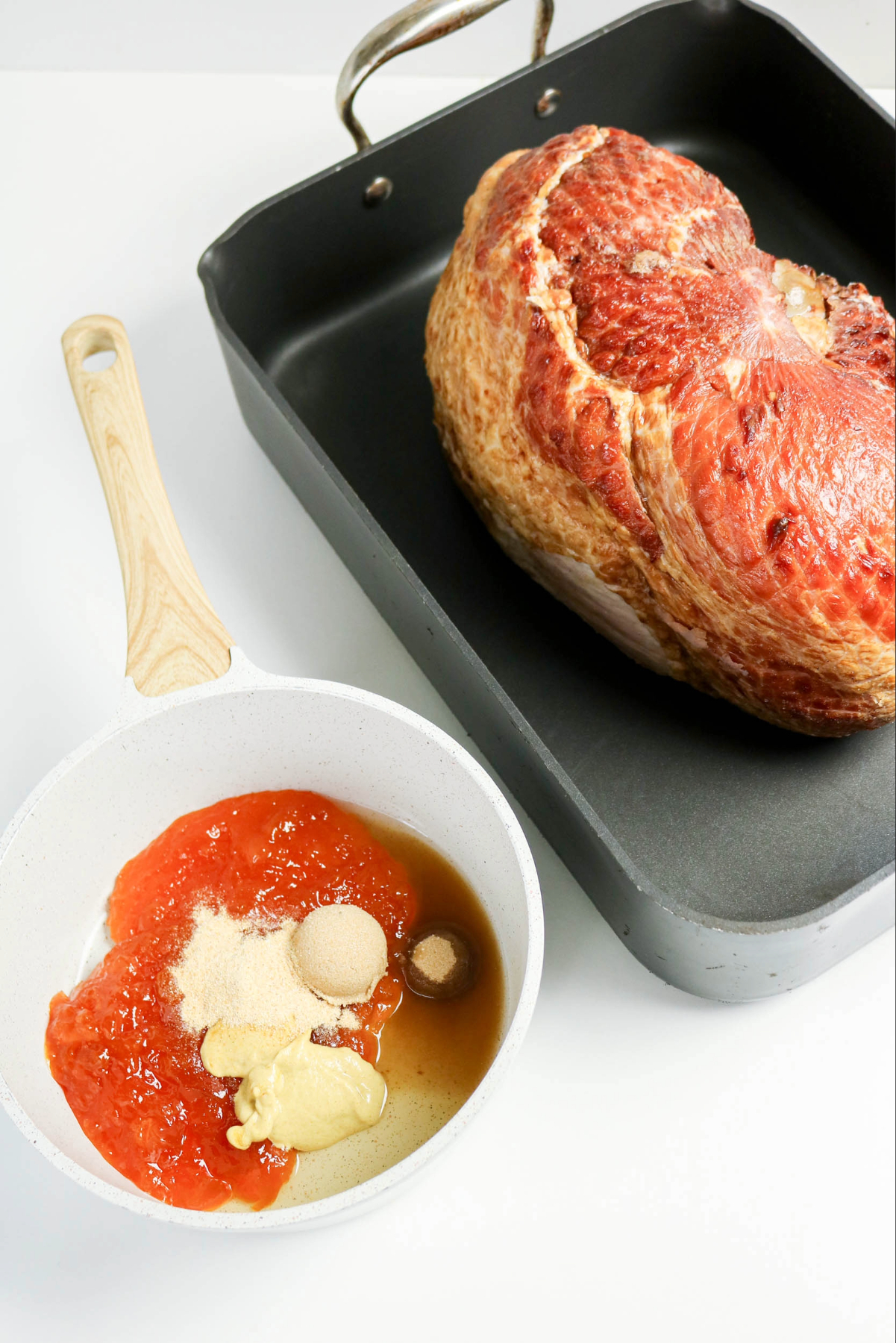 Apricot preserve with spices in a small white saucepan.