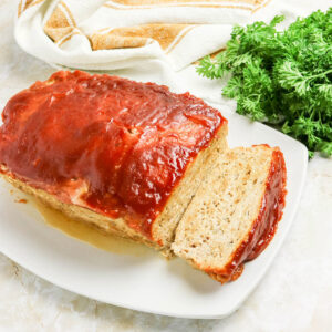 A slice of chicken meatloaf on a serving dish.