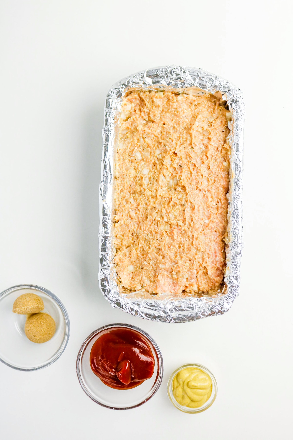 Meatloaf mix in a loaf pan before baking.