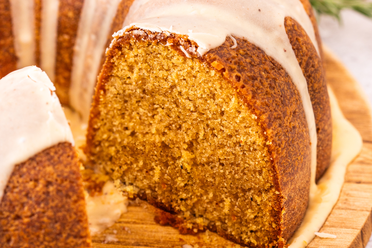 A slice of cake on a wood cake platter. 