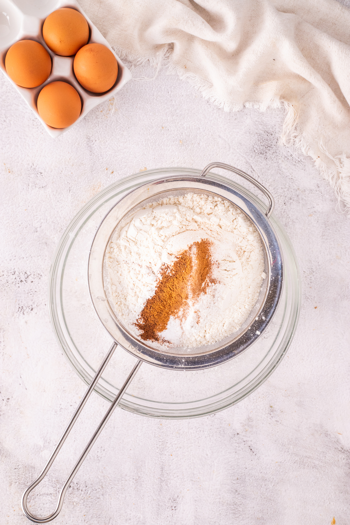 Dry cake ingredients sifted into a clear mixing bowl. 