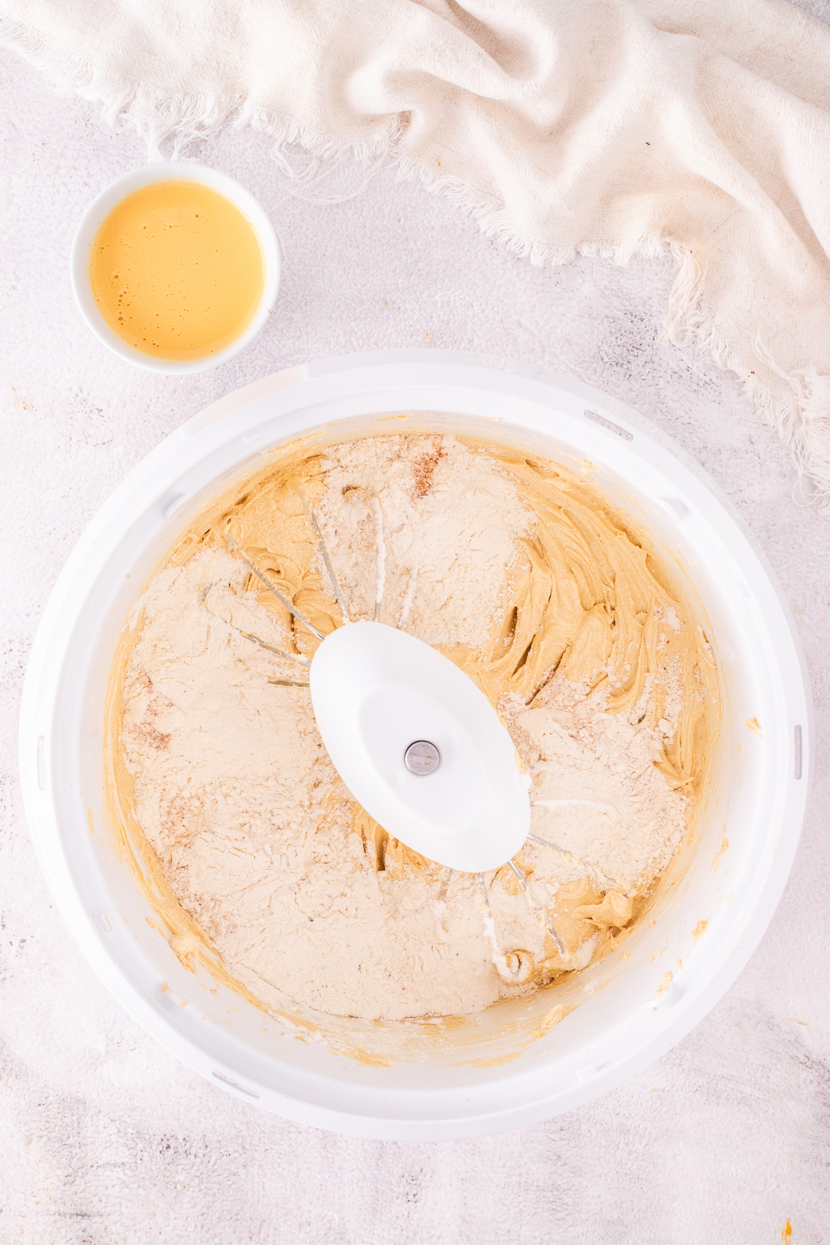 Mixing bowl with batter and alternating flour and eggnog into the batter.