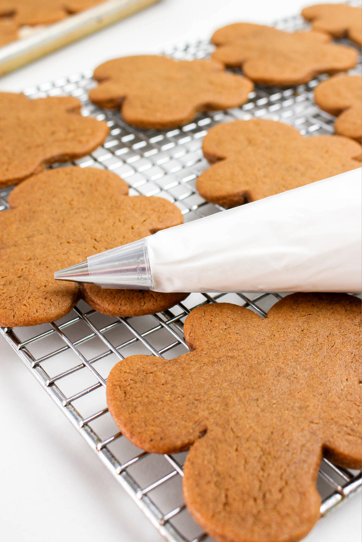 a piping bag with royal icing near cutout cookies before decorating.