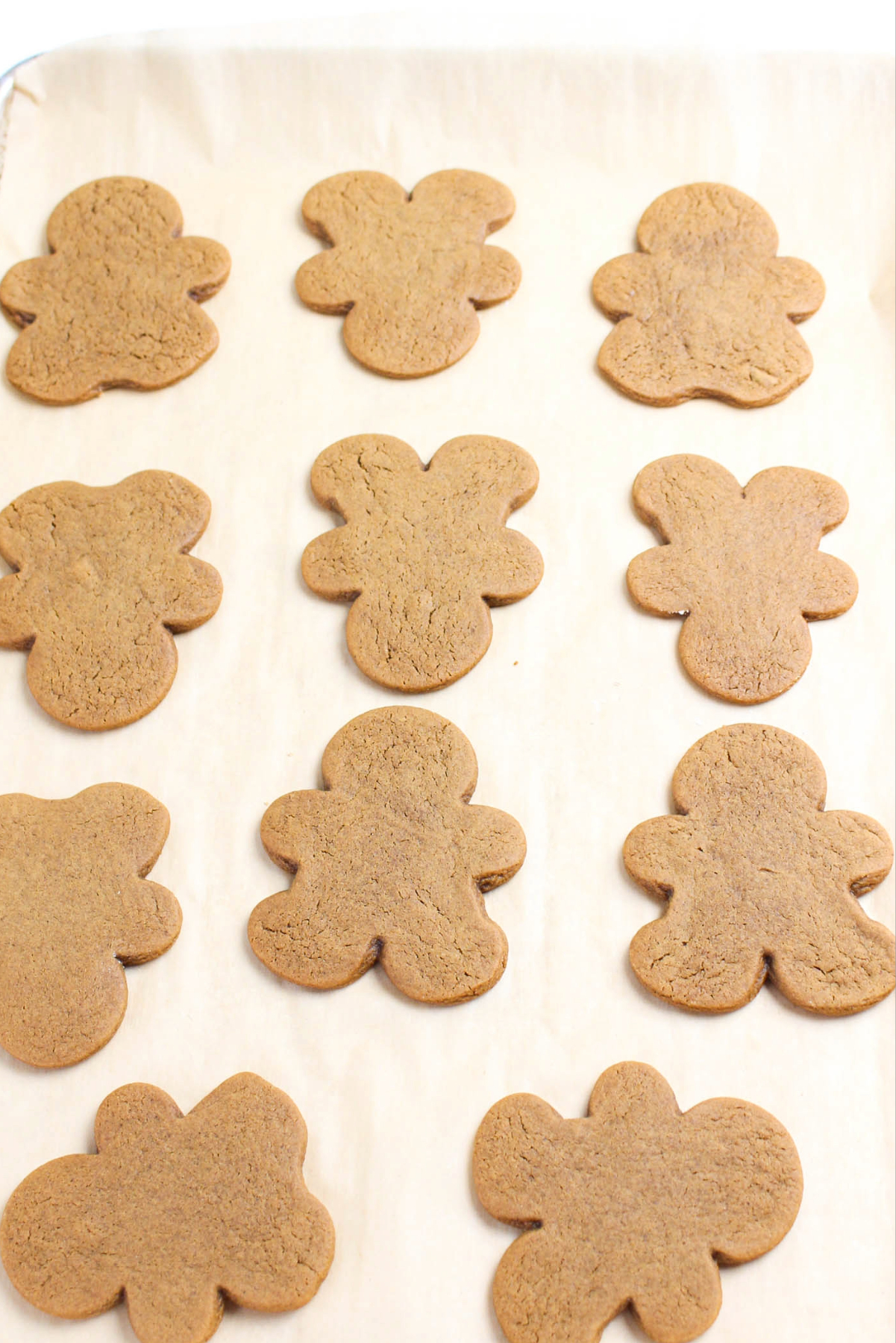 Cutout gingerbread men cookies on a baking sheet.