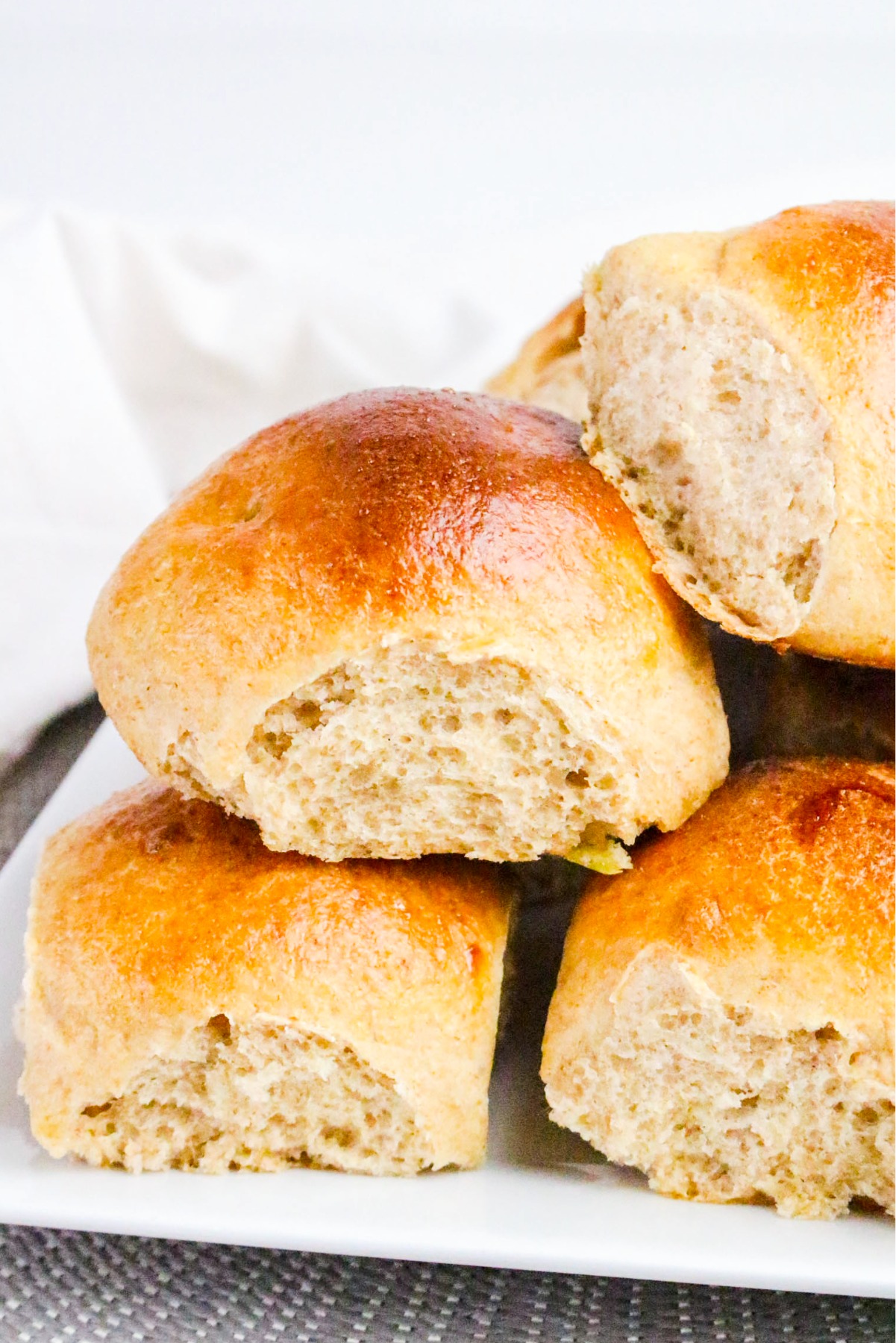 A plate with homemade rolls piled on to of each other.
