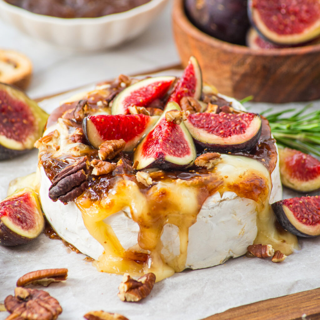 brie cheese melted and topped with fig jam and fresh slices of figs.