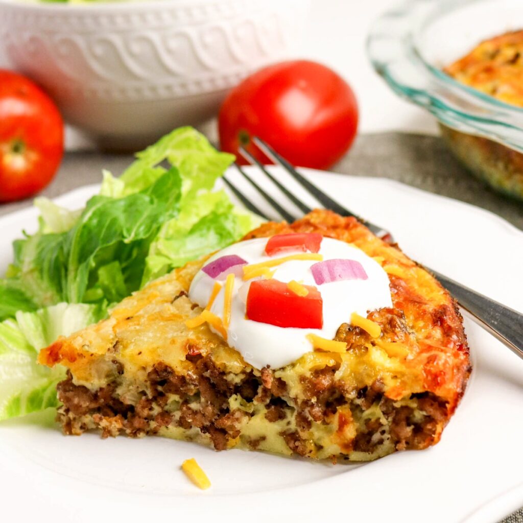 A slice of ground beef hamburger pie with salad on the side.