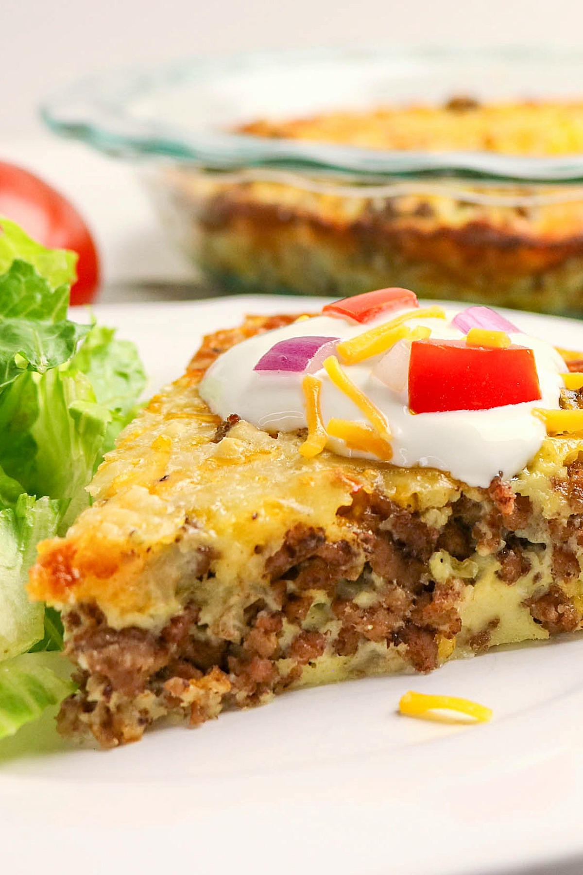 A piece of a savory pie made with hamburger on a white dinner plate.