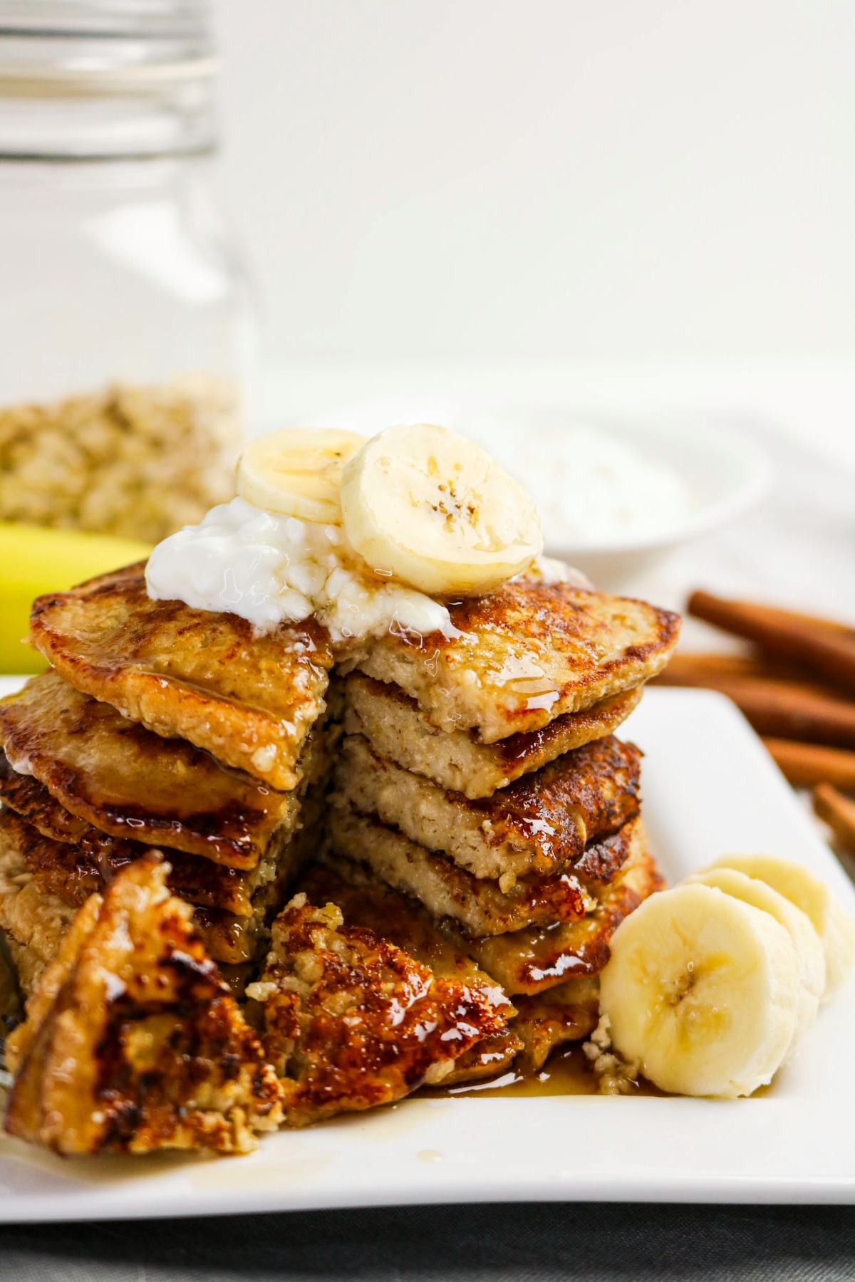 Pancakes on a white plate sliced into before eating.