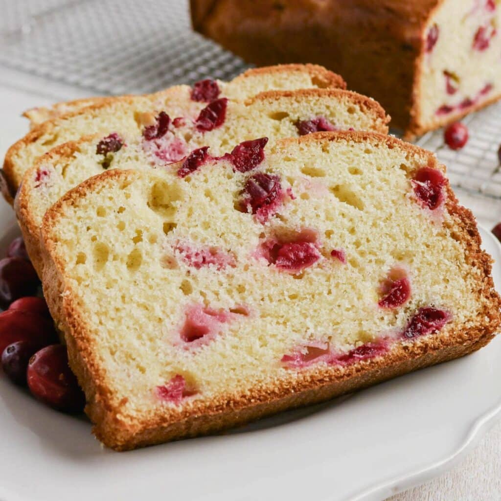 Three slices of cranberry bread on a white plate.