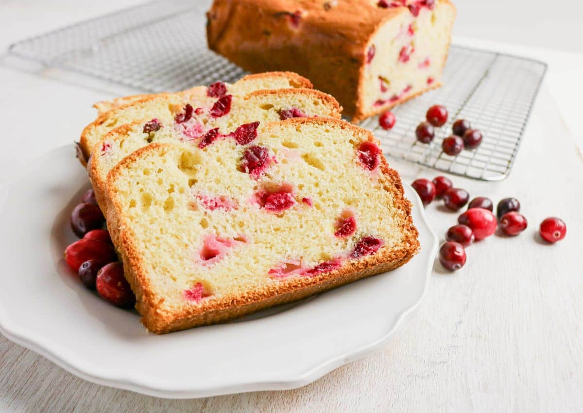 Three slices of cranberry cream cheese bread on a white plate.