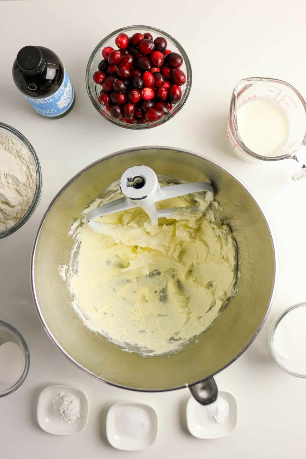 Butter and sugar being creamed in a stainless steel mixing bowl.