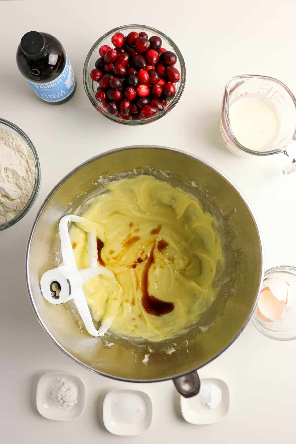 Vanilla extract being mixed into a batter in a stainless steel mixing bowl.