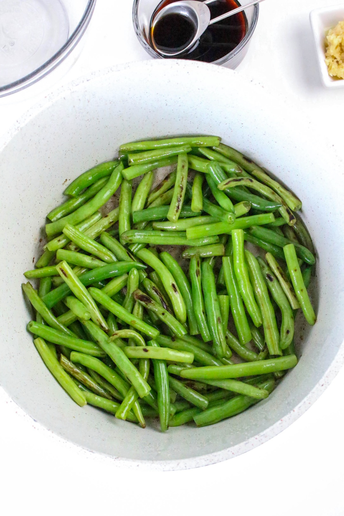 Sautéed green beans in a large skillet.