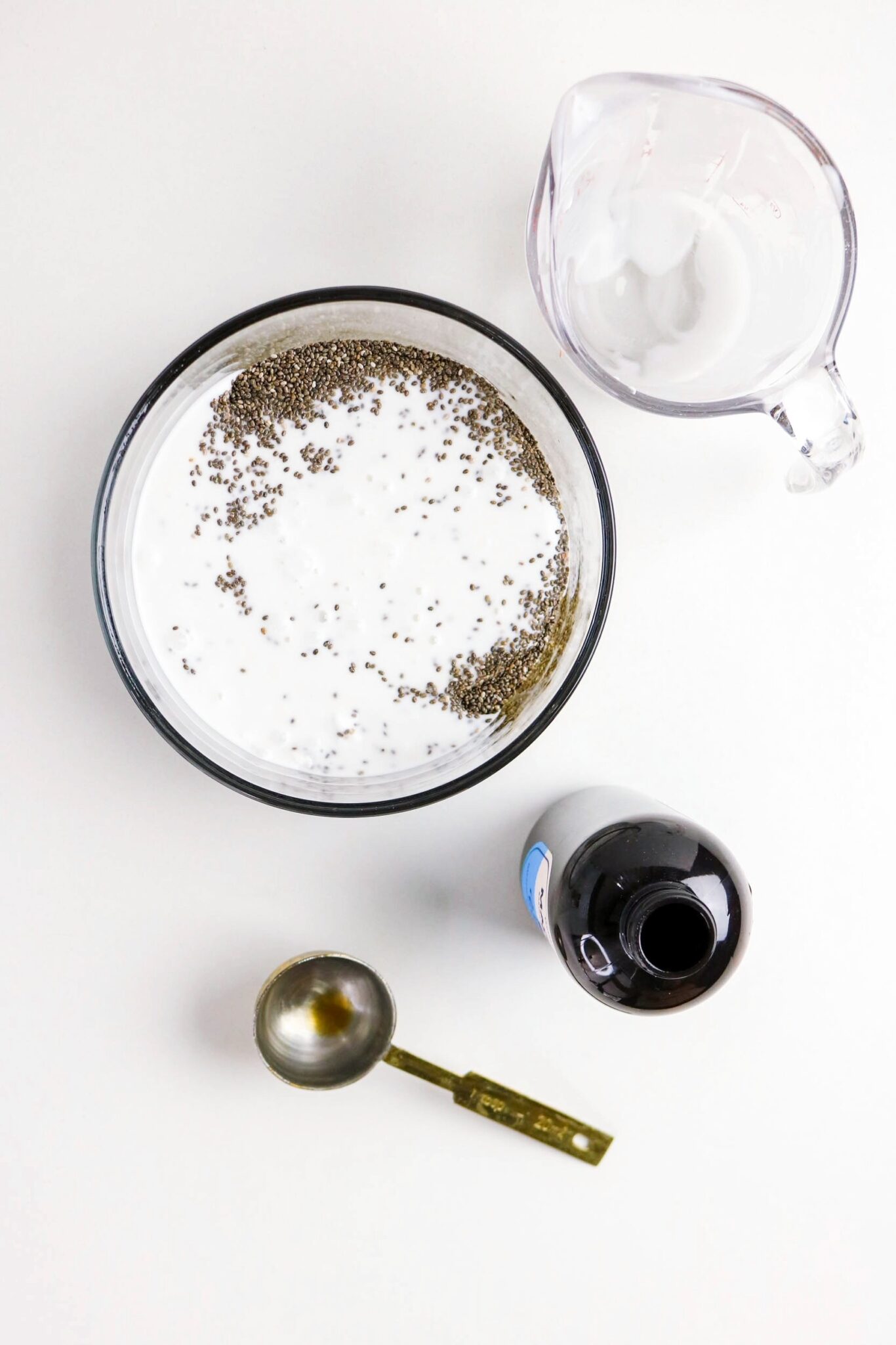 Ingredients in a clear mixing bowl for coconut milk chia pudding.
