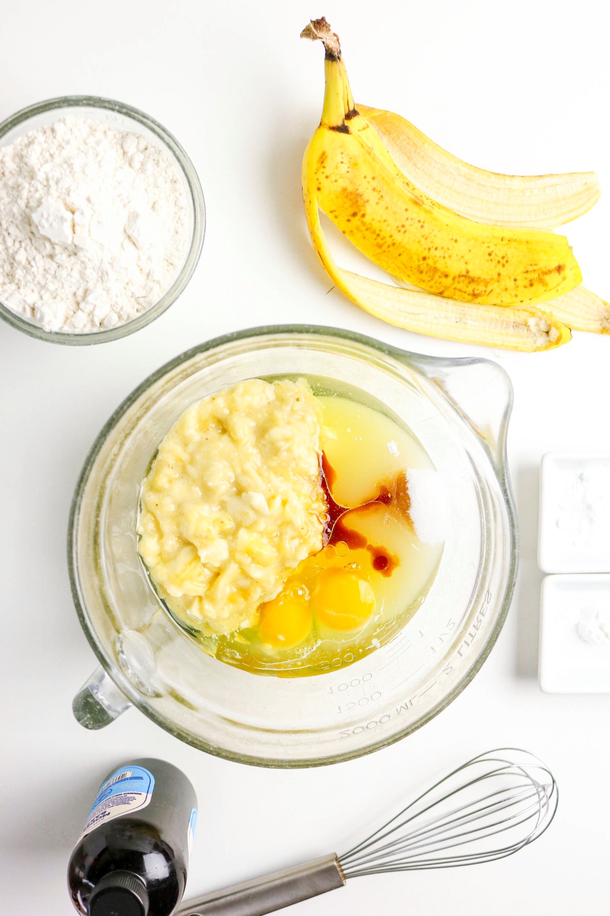 Cottage cheese with eggs and vanilla in a clear mixing bowl before blending.