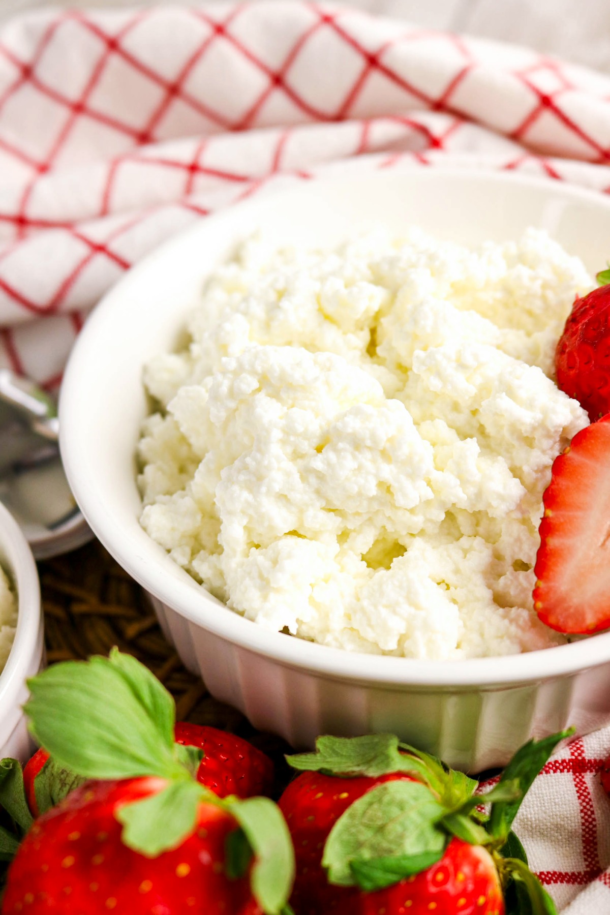 cottage cheese in a bowl with fresh strawberries on the side.