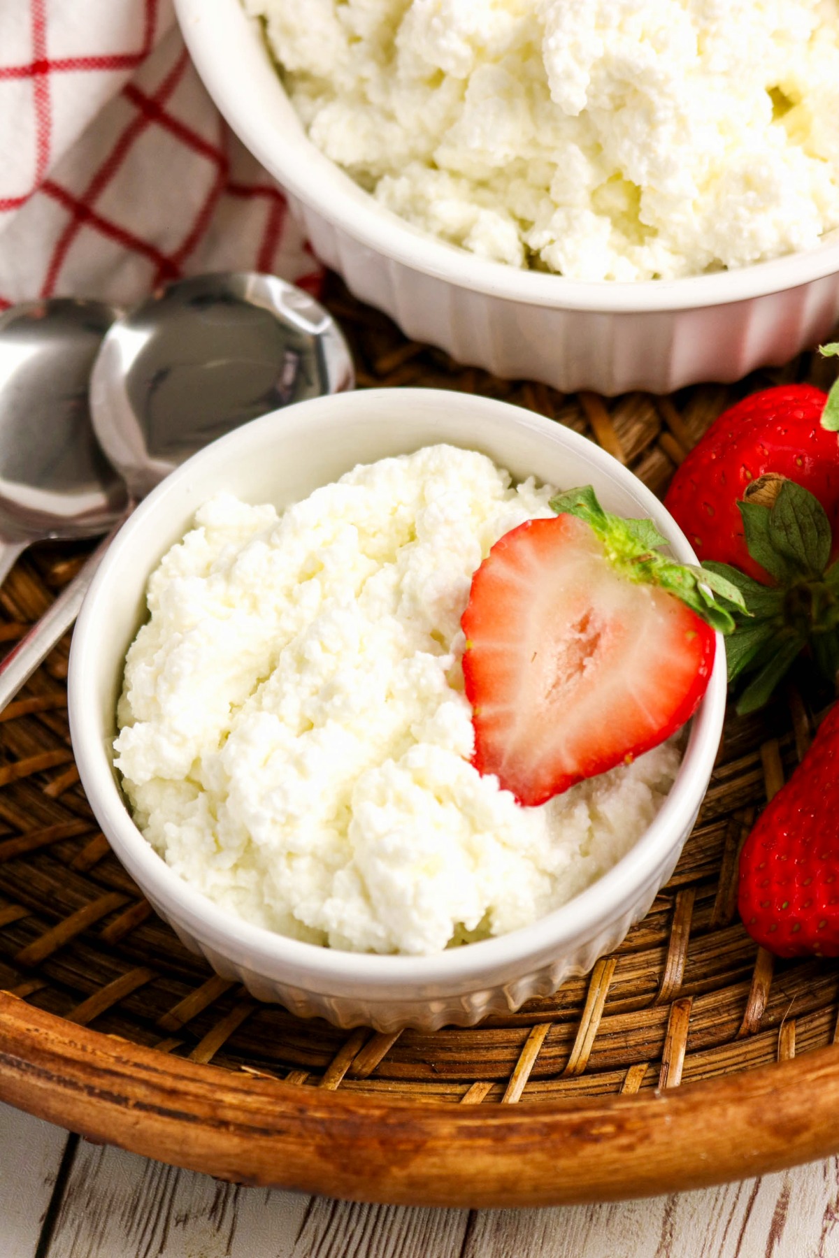 Homemade cottage cheese in a white bowl with a sliced strawberry.