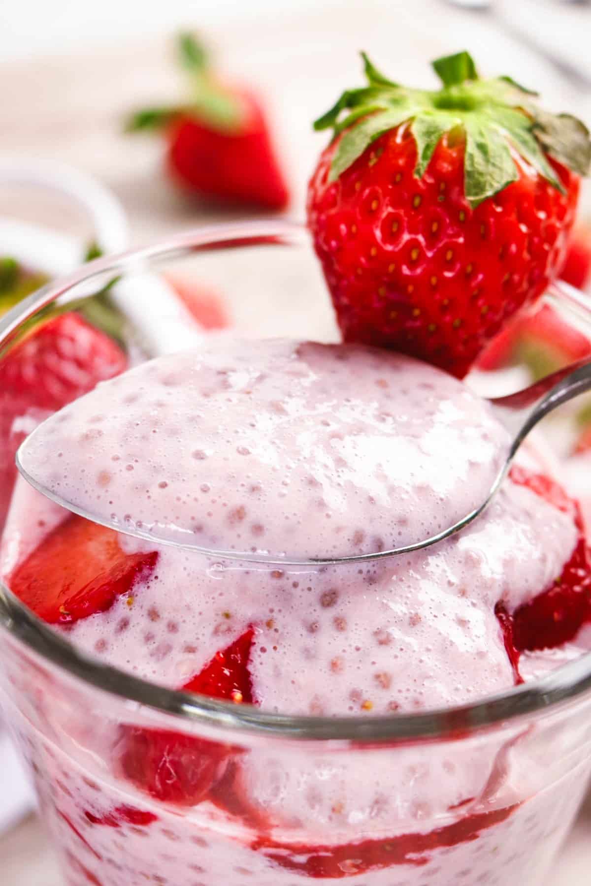 A spoonful of chia pudding made with coconut milk and strawberries.