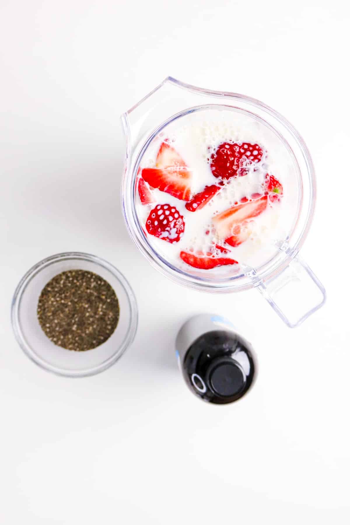 almond milk with sliced strawberries in a blender.