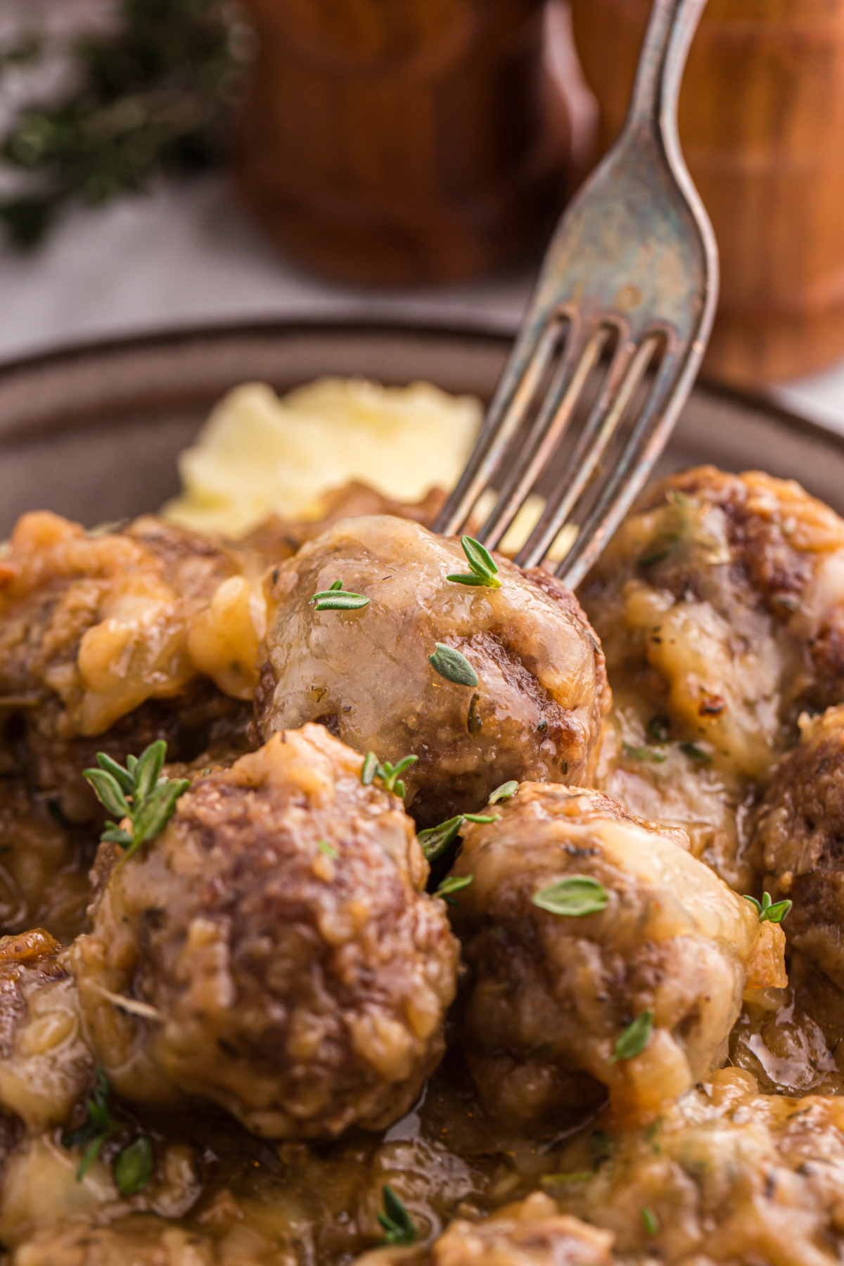 A fork sticking into a meatball.