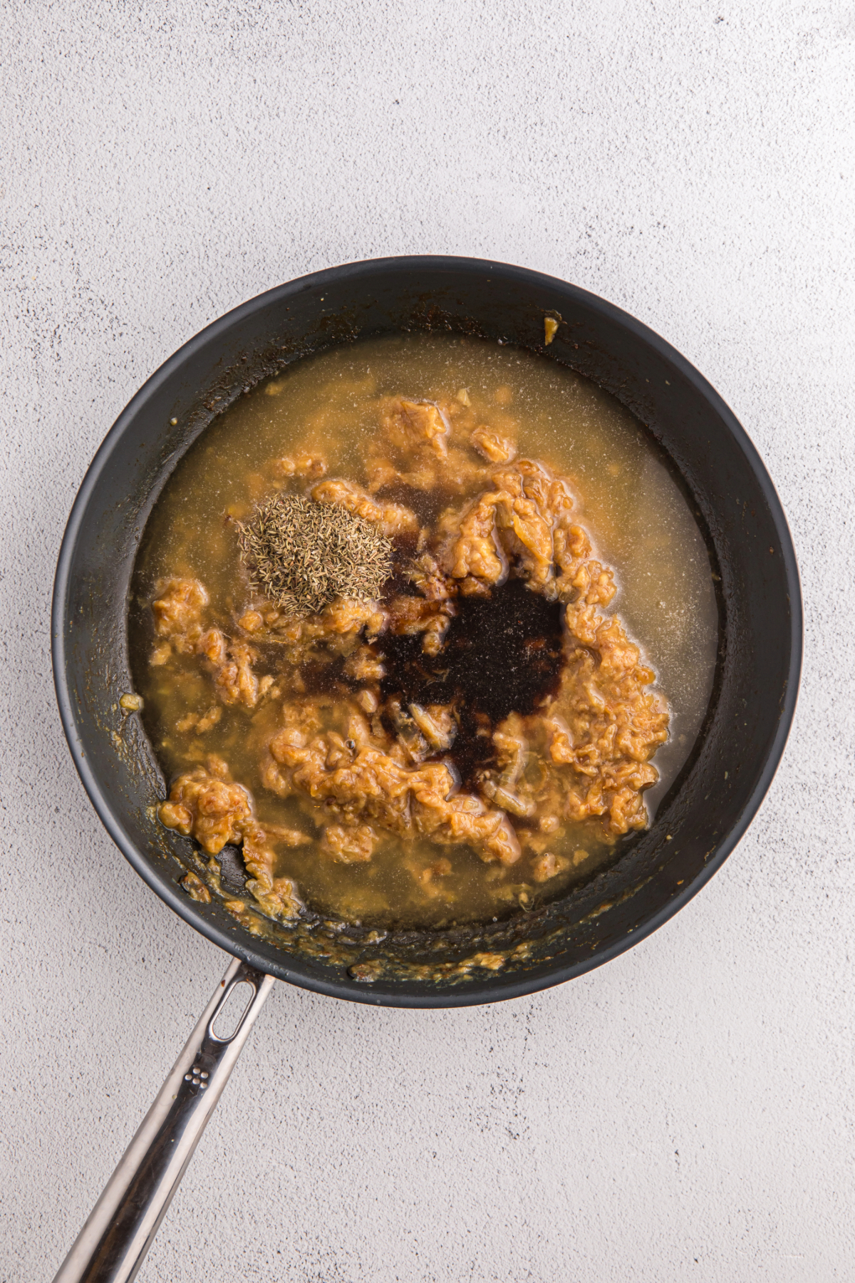 Cook onions with spices and beef broth in a skillet.