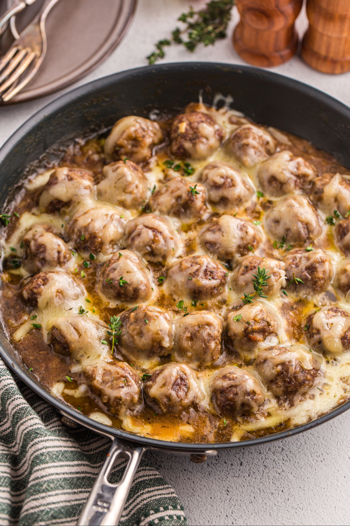 Cooked French onion meatballs in a large skillet.