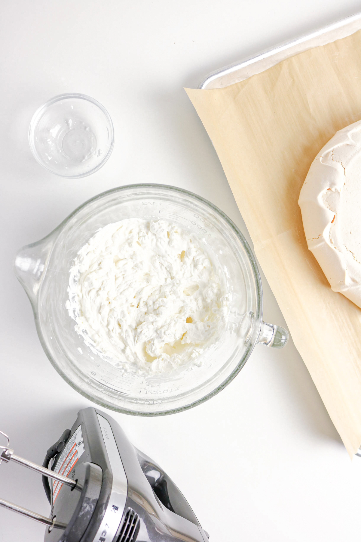 homemade whipped cream in a clear mixing bowl.
