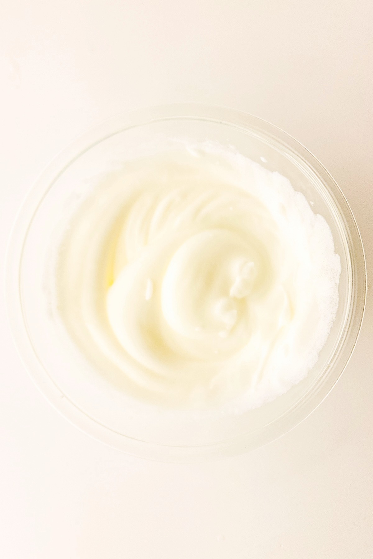 Whipped egg whites in a clear mixing bowl.
