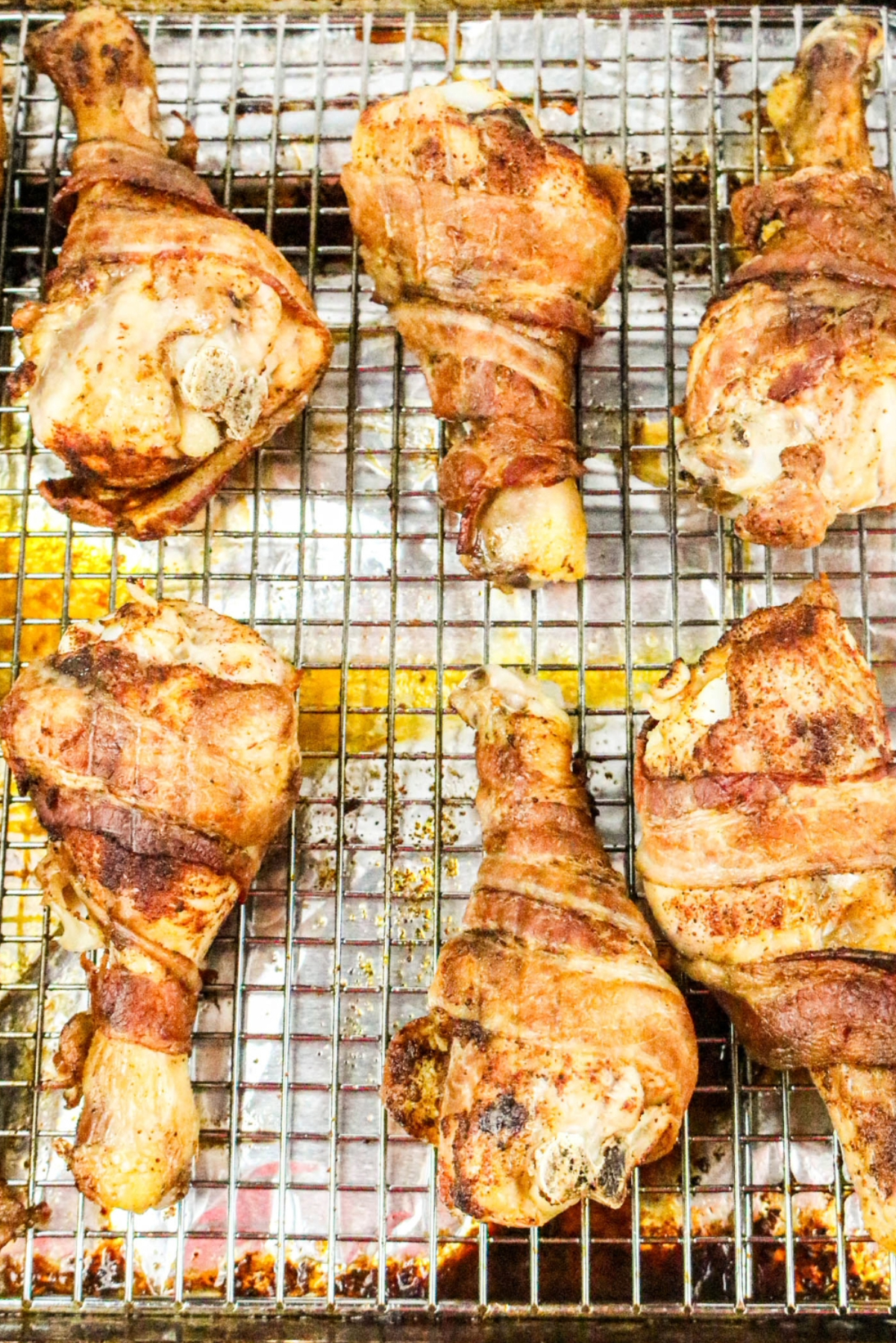 cooked chicken drumsticks on a baking rack.